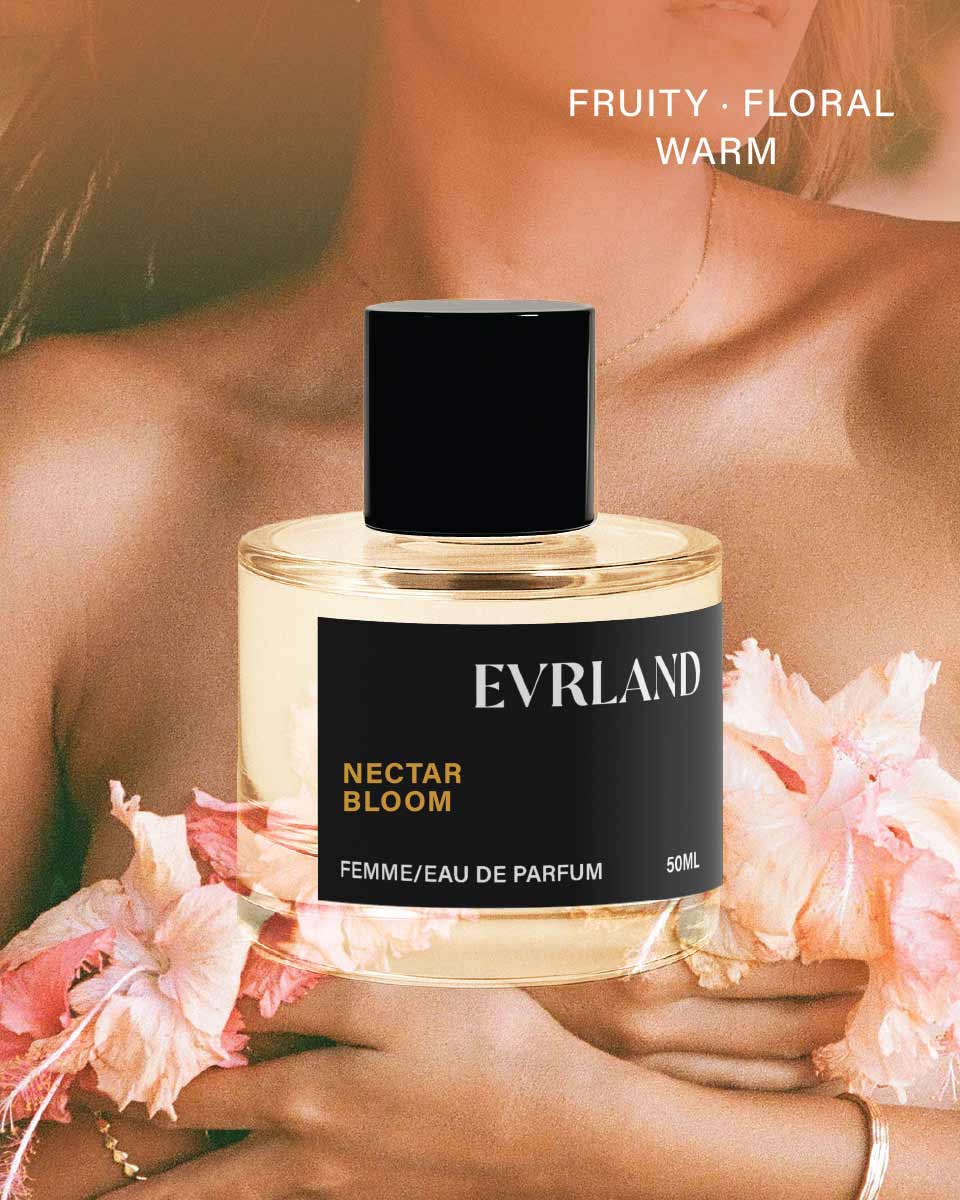 Perfume bottle labeled 'Evrland Nectar Bloom' held by a person with flowers, against a blurred background.